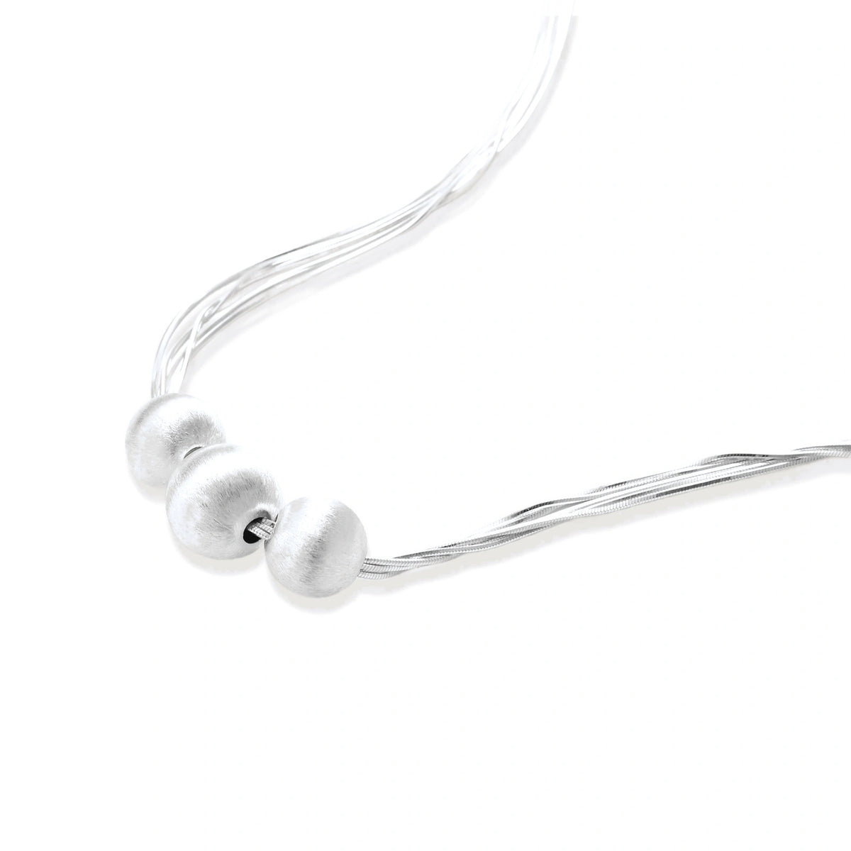 Sterling silver multi-strand necklace with three brushed round beads on cream background