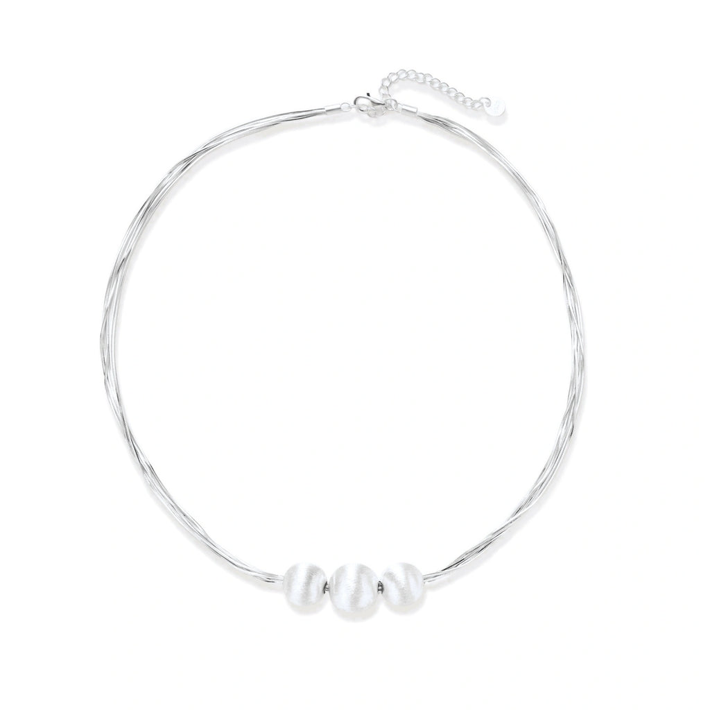Sterling silver multi-strand necklace with three brushed round beads on cream background