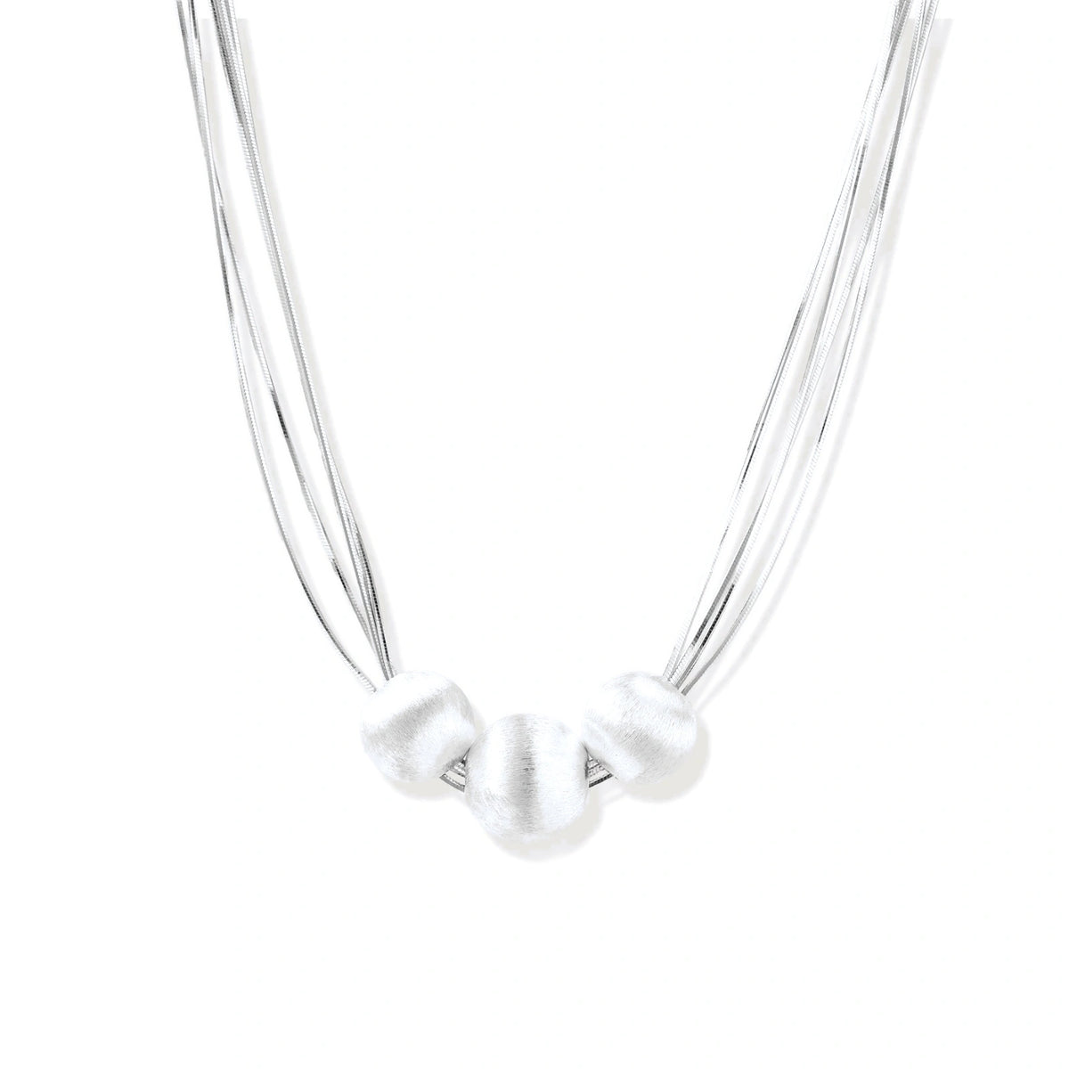 Sterling silver multi-strand necklace with three brushed round beads on cream background