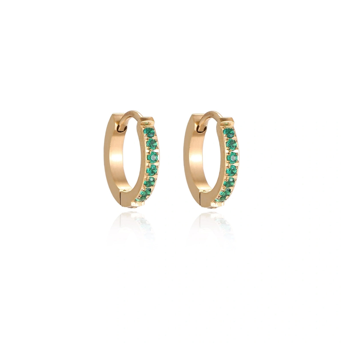 Pair of small gold huggie hoop earrings with bright green cubic zirconia stones on cream background