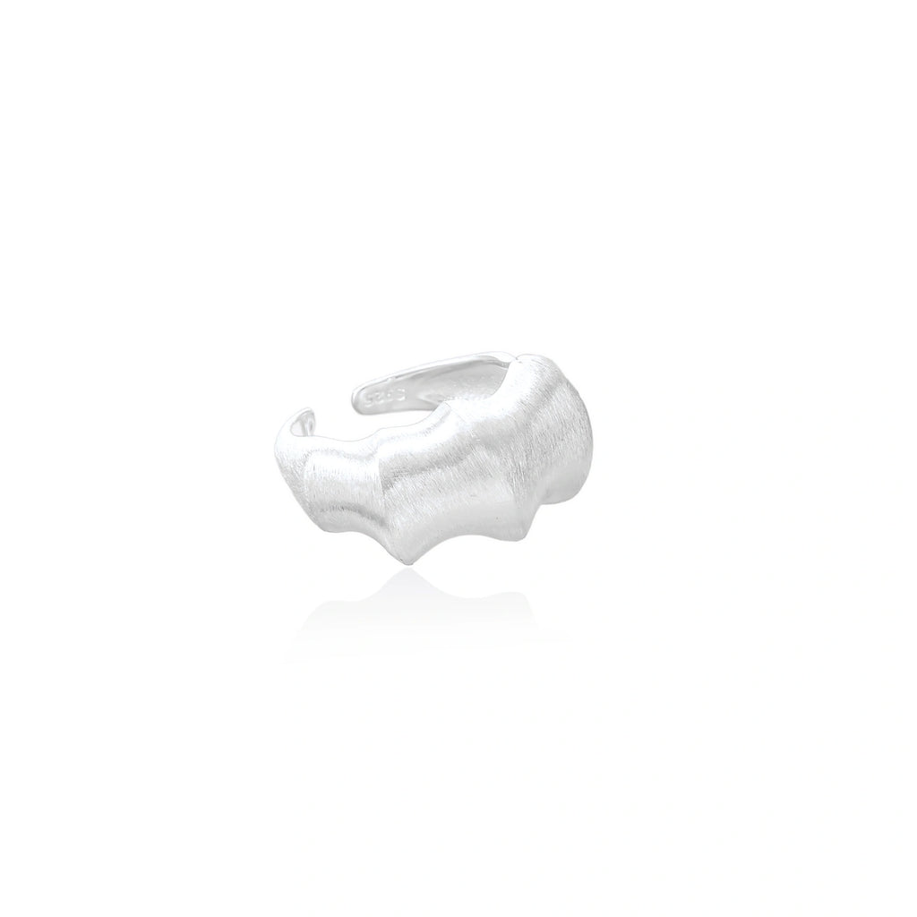 Brushed sterling silver ring with organic wave-like edges and adjustable cuff design on white background