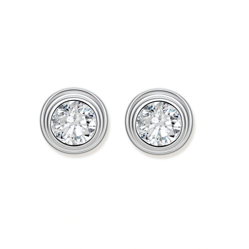 Close-up of sterling silver stud earrings featuring concentric circular frames with brilliant moissanite centers