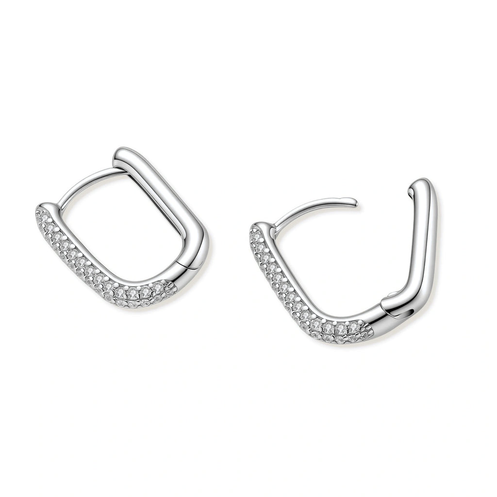 Close-up of platinum-plated sterling silver huggie hoops with pavé crystal setting on white background.