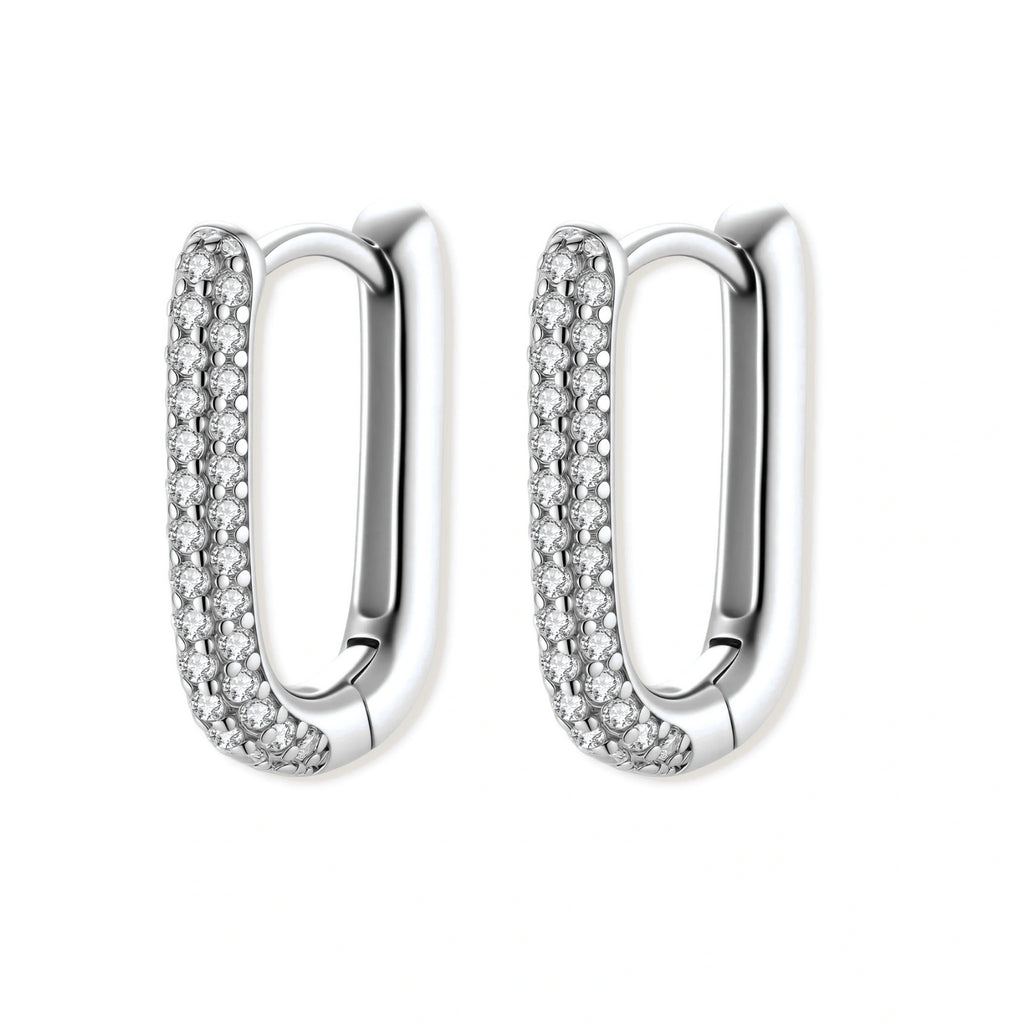 Close-up of platinum-plated sterling silver huggie hoops with pavé crystal setting on white background.