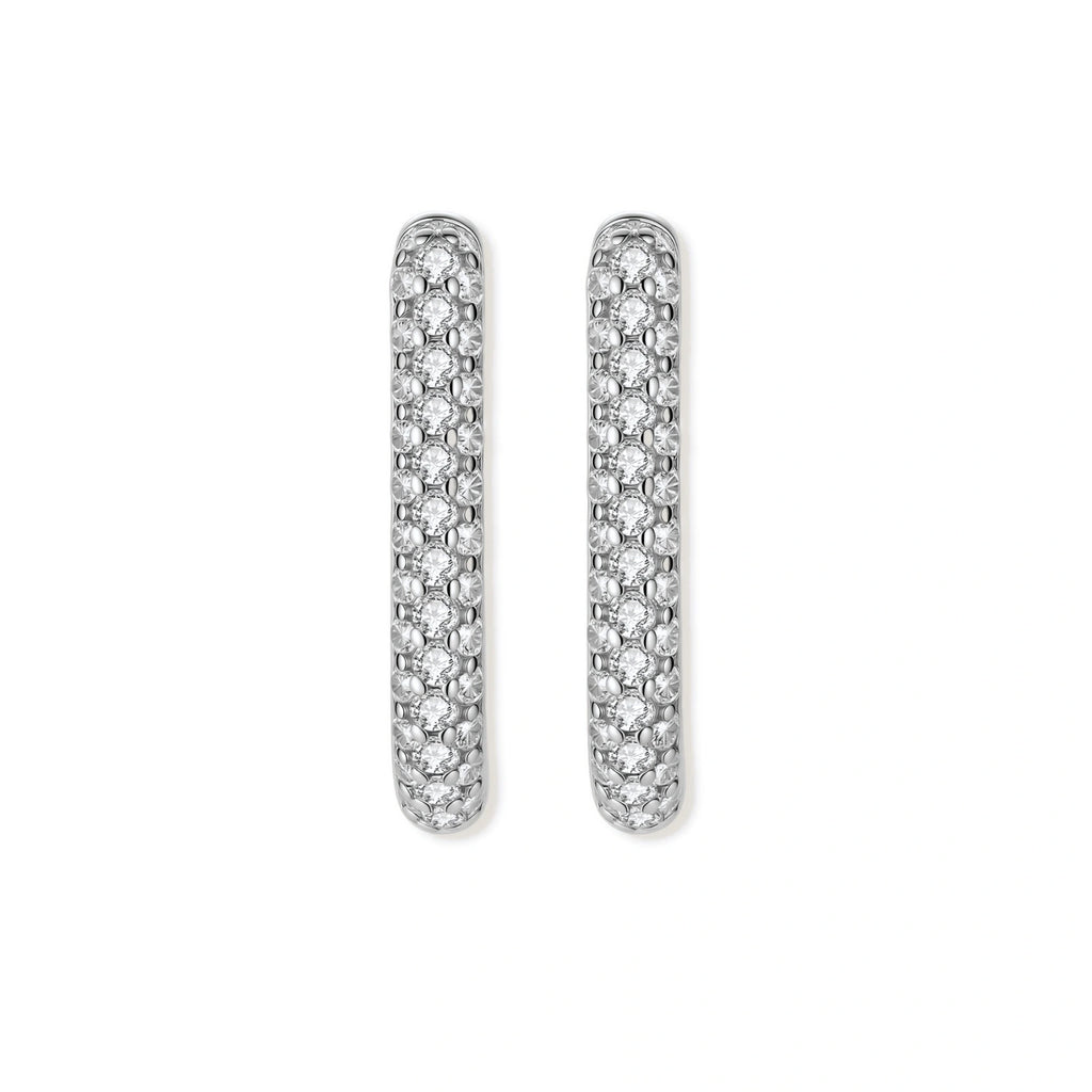 Close-up of platinum-plated sterling silver huggie hoops with pavé crystal setting on white background.