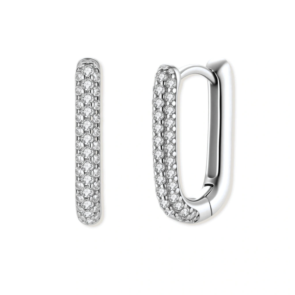 Close-up of platinum-plated sterling silver huggie hoops with pavé crystal setting on white background.