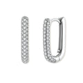 Close-up of platinum-plated sterling silver huggie hoops with pavé crystal setting on white background.