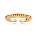 Adjustable gold-plated ring with row of sparkling crystals on ribbed band, shot against cream background